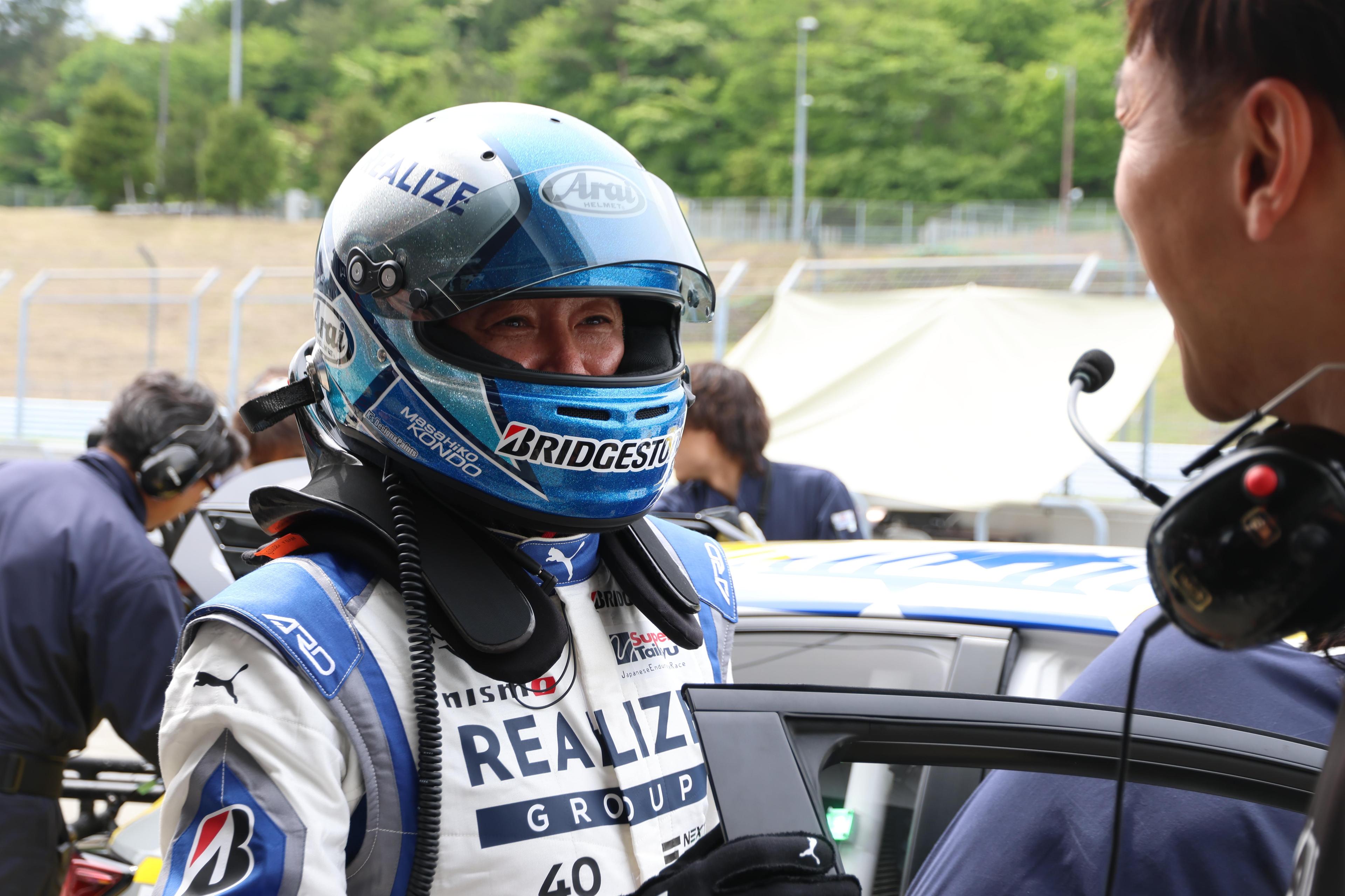 白いレーシングスーツとおニューのヘルメットでテスト走行に挑むマッチ。モリゾウは「まるで16歳の少年のような表情。自動車が好きなんだなということを心の底から理解できた」とコメント